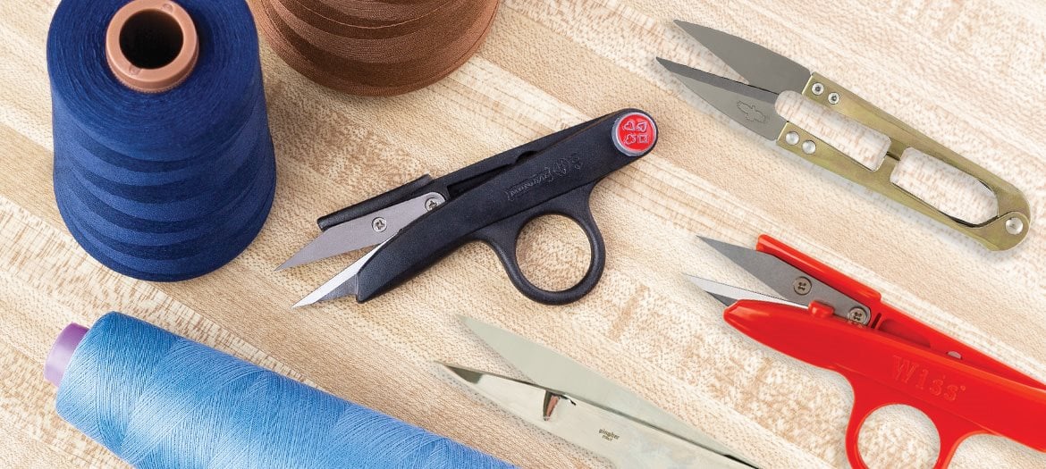 Thread Snips with Spun Polyester Thread Spools on Sewing Table